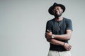 Happy african american man wearing glasses and a hat stands smiling with his arms crossed on his chest Royalty Free Stock Photo