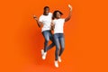 Happy african-american man and woman making selfie while jumping up Royalty Free Stock Photo