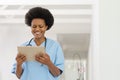 Happy african american mid adult female doctor using digital tablet in hospital Royalty Free Stock Photo