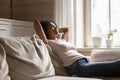 Smiling biracial woman relax on cozy couch in living room Royalty Free Stock Photo