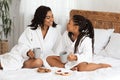 Happy African American Mom And Daughter In Bathrobes Having Snacks In Bed Royalty Free Stock Photo