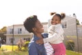 Happy african american mother and daughter spending time together and playing football outside Royalty Free Stock Photo