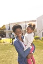 Happy african american mother and daughter spending time together and playing football outside Royalty Free Stock Photo