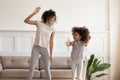 Happy african american mother doing morning exercises with excited daughter. Royalty Free Stock Photo
