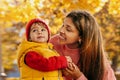 a happy African-American mother with her baby in an autumn park with yellow leaves Royalty Free Stock Photo