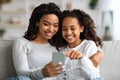 Happy african american mother and kid using smartphone together Royalty Free Stock Photo
