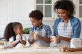 Happy African American mother with little kids kneading dough Royalty Free Stock Photo