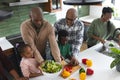 Happy african american multi generation family chopping vegetables in kitchen, slow motion Royalty Free Stock Photo