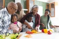 Happy african american multi generation family chopping vegetables in kitchen, slow motion Royalty Free Stock Photo