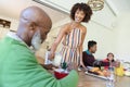 Happy african american multi generation family sitting at table during breakfast and smiling