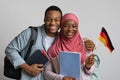 Cheerful african muslim students couple holding german flag, closeup portrait Royalty Free Stock Photo