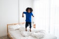 Happy African American naughty child jumping on the bed with happiness Royalty Free Stock Photo