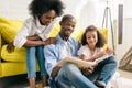 happy african american parents and little daughter reading book together