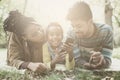 Happy African American parents in park with daughter using mobil Royalty Free Stock Photo