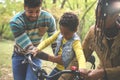 Happy African American parents teaching their little girl to driving bike in park. Royalty Free Stock Photo