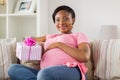 Happy african american pregnant woman with gift Royalty Free Stock Photo