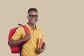 Happy African American student with bag and books standing on beige copy space background Royalty Free Stock Photo