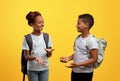 Happy african american schoolers having conversation on yellow Royalty Free Stock Photo