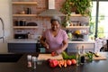 Happy african american senior woman cooking in kitchen Royalty Free Stock Photo