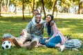 happy african american soldier sitting on grass with family