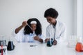 Happy african american student girl and boy is learning and test science chemical with colorful liquid in tube test and beaker in Royalty Free Stock Photo