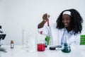 Happy african american student girl is learning and test science chemical with colorful liquid in tube test and beaker in Royalty Free Stock Photo