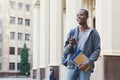 Happy african-american student texting in university campus Royalty Free Stock Photo