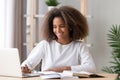 Happy african american teen high school student studying with laptop