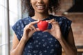 Happy African American volunteer girl holding red heart