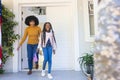 Happy african american wife and daughter welcoming male soldier outdoors with usa flag, copy space