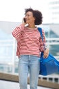 Happy african american woman with bag talking on mobile phone in the city Royalty Free Stock Photo