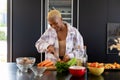 Happy african american woman cooking in kitchen, chopping vegetables Royalty Free Stock Photo