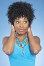 Happy African American woman covering ears over while looking away colored background Royalty Free Stock Photo