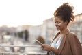 Happy african american woman in evening sequin dress and glitter on face using mobile phone Royalty Free Stock Photo