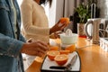 Happy african american woman and her teenage daughter making fresh orange juice Royalty Free Stock Photo