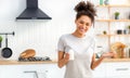 Happy african american woman in home kitchen holding bottle of nutritional supplements, healthy lifestyle Royalty Free Stock Photo