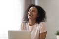 Happy African American woman laughing at funny joke, using laptop Royalty Free Stock Photo