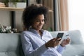Happy African American woman make payment on cellphone Royalty Free Stock Photo