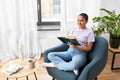 Happy african american woman reading book at home Royalty Free Stock Photo