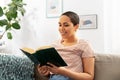 Happy african american woman reading book at home Royalty Free Stock Photo