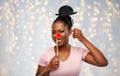 Happy african american woman with red clown nose