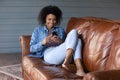 Happy African American woman relax using smartphone gadget Royalty Free Stock Photo