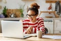 Happy african american woman smiling during online lesson while studying from home on laptop Royalty Free Stock Photo