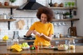 Happy african american woman standing at the cuisine table at home kitchen drinking dietary supplements Royalty Free Stock Photo