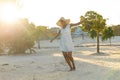 Happy african american woman in sunhat and white beach dress dancing on sunny beach Royalty Free Stock Photo