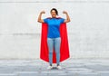 Happy african american woman in superhero red cape