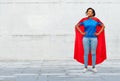 Happy african american woman in superhero red cape