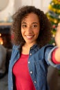 Happy african american woman taking selfie, christmas decorations in background Royalty Free Stock Photo