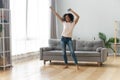 Happy African American woman using phone, dancing at home Royalty Free Stock Photo
