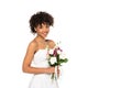 Happy african american woman in wedding dress holding bouquet and looking at camera Royalty Free Stock Photo